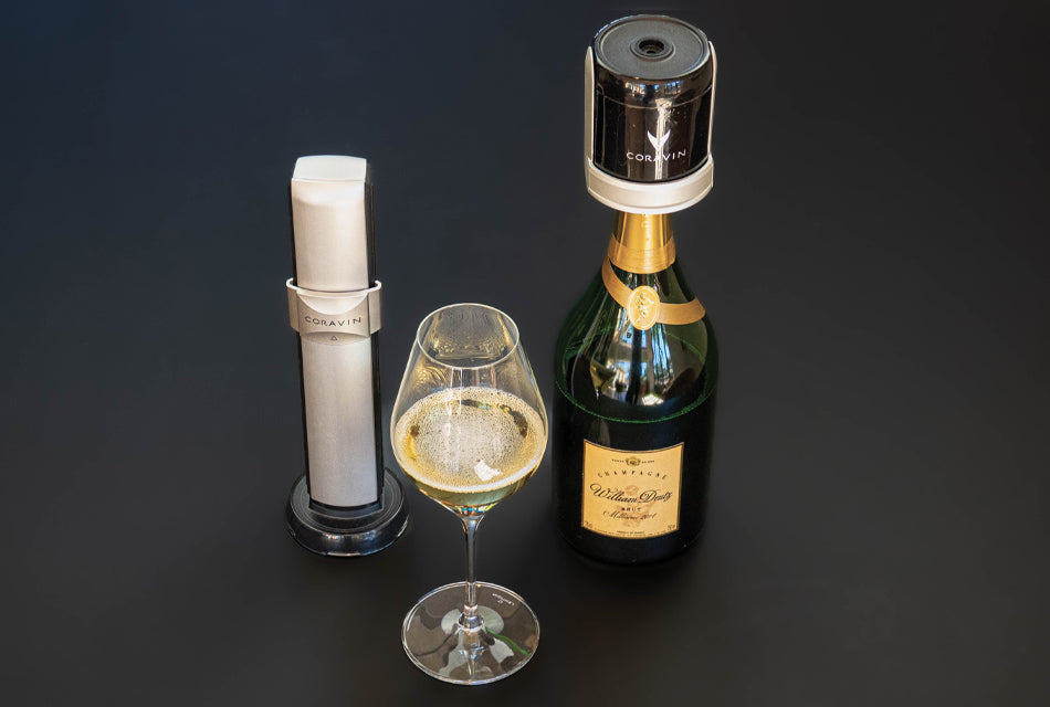 Coravin Sparkling wine preservation system with a champagne bottle and a glass of sparkling wine on a black background.