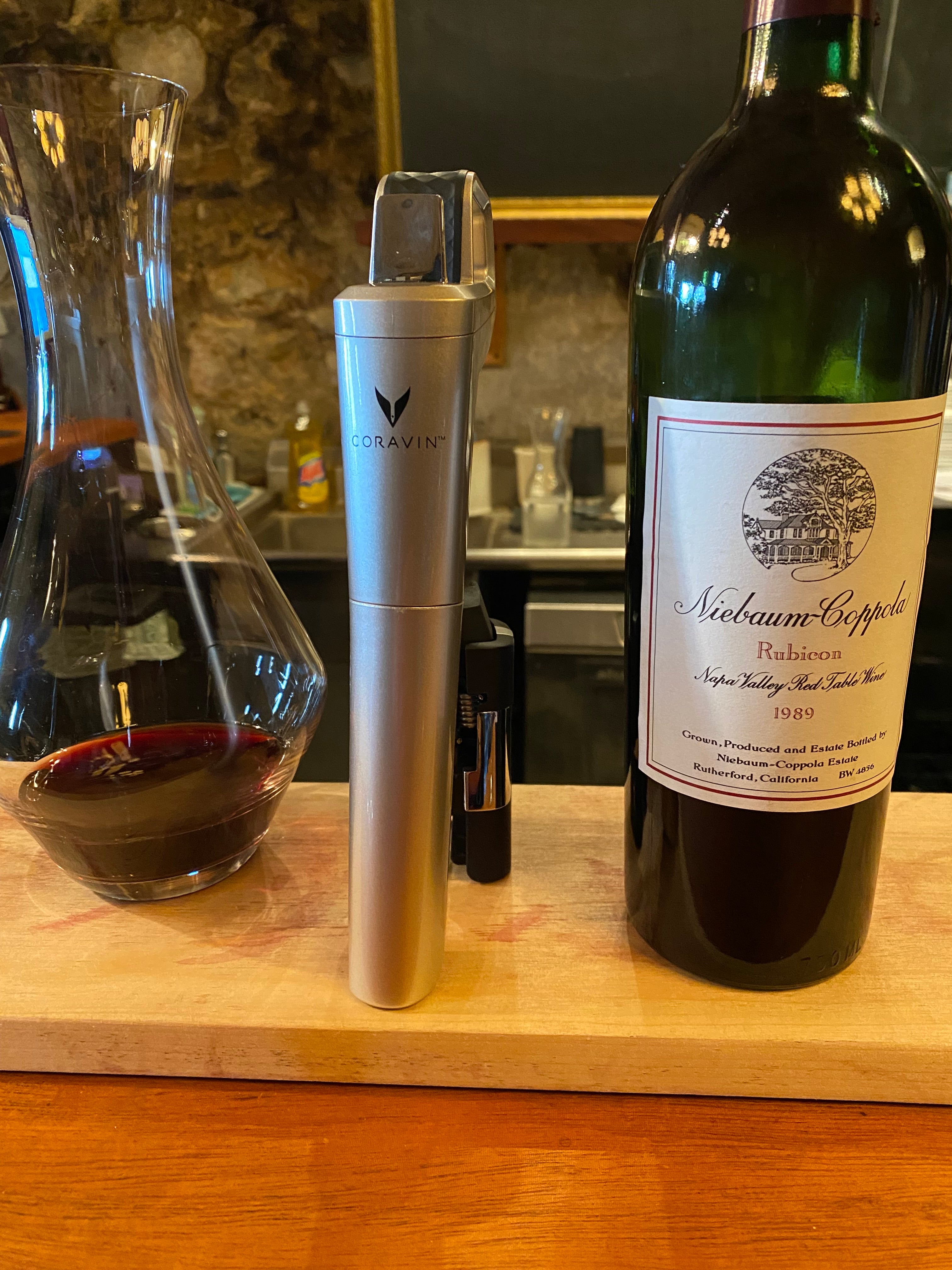 Coravin wine preservation system next to a decanter and bottle of Niebaum-Coppola Rubicon 1989 Napa Valley red wine.
